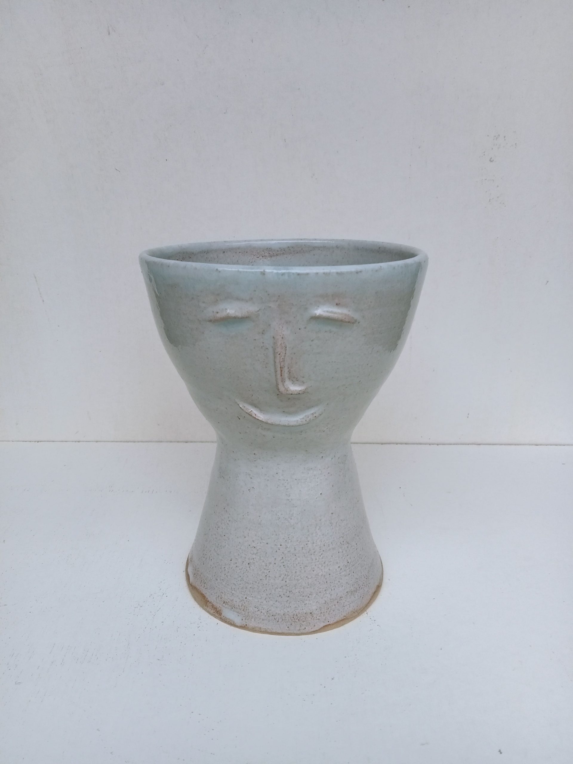 grand cache pot avec un visage dessus