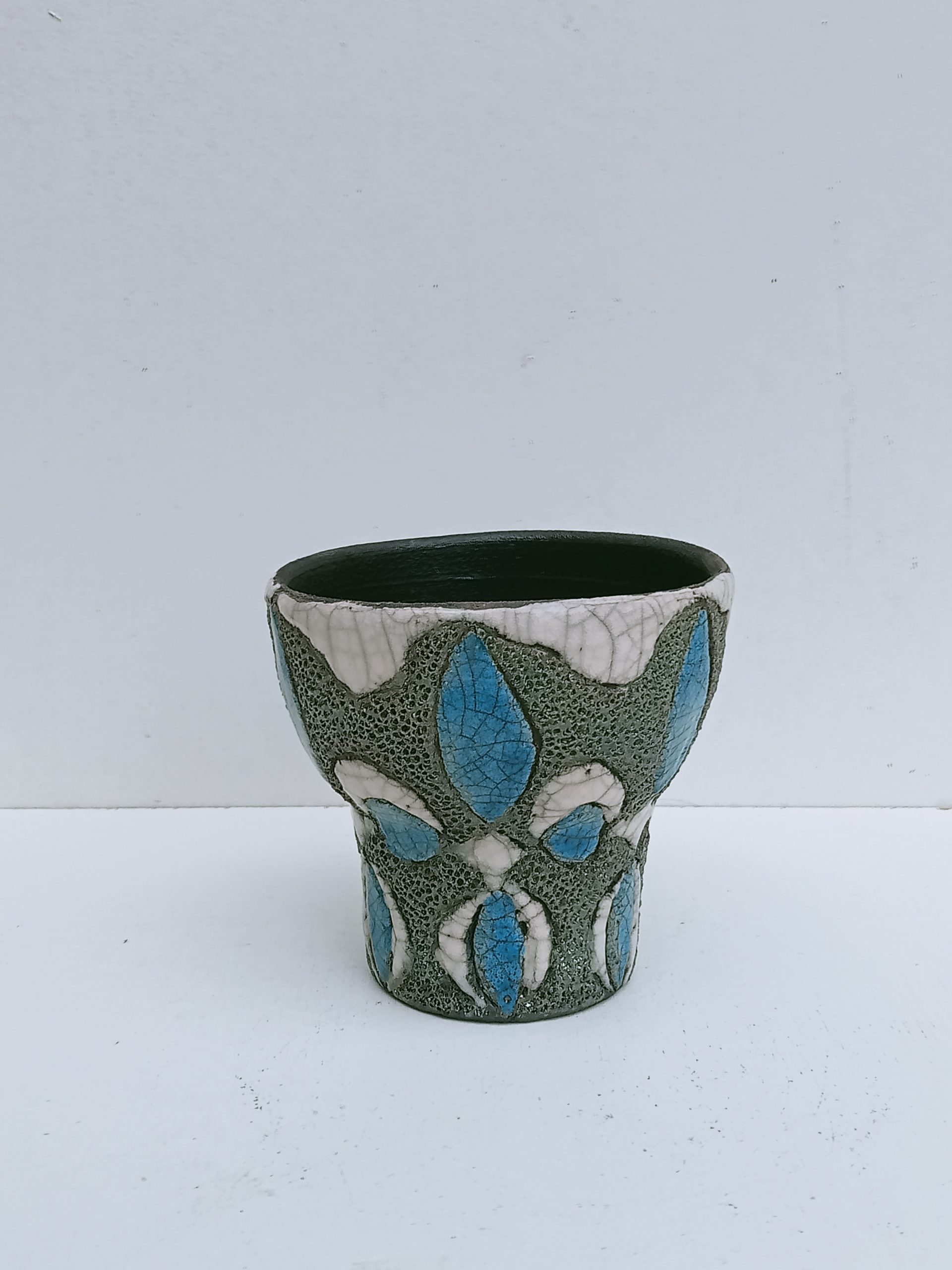cache pot en raku vert avec des motifs bleus et blancs